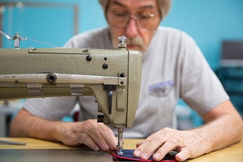 FAA Master Rigger Sandy Reid stitching a patch with a sewing machine at USAPR parachute rigging school in Eloy, AZ