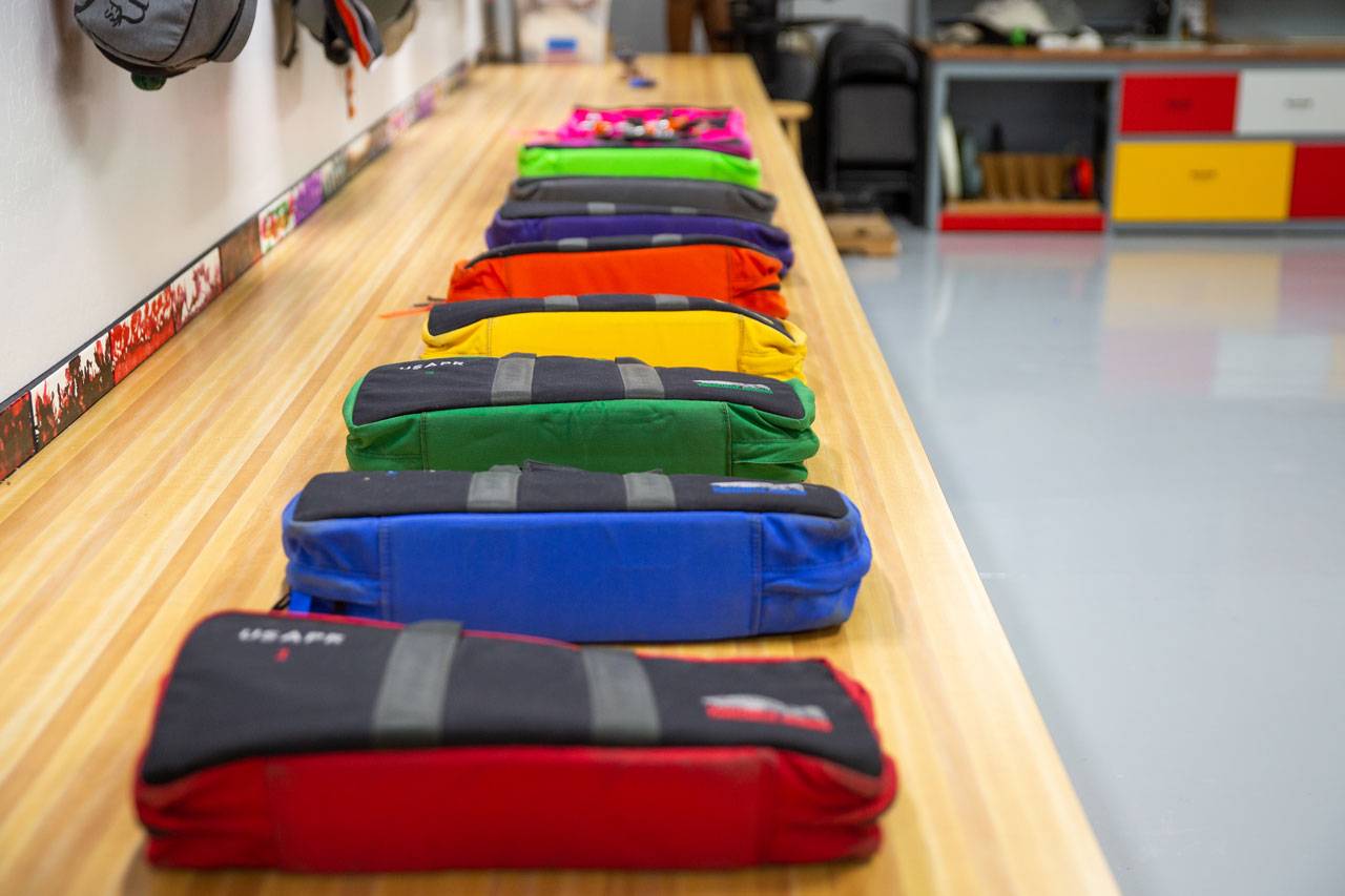 Parachute packing table with multi-color rigging kits lined up at USAPR in Eloy, AZ